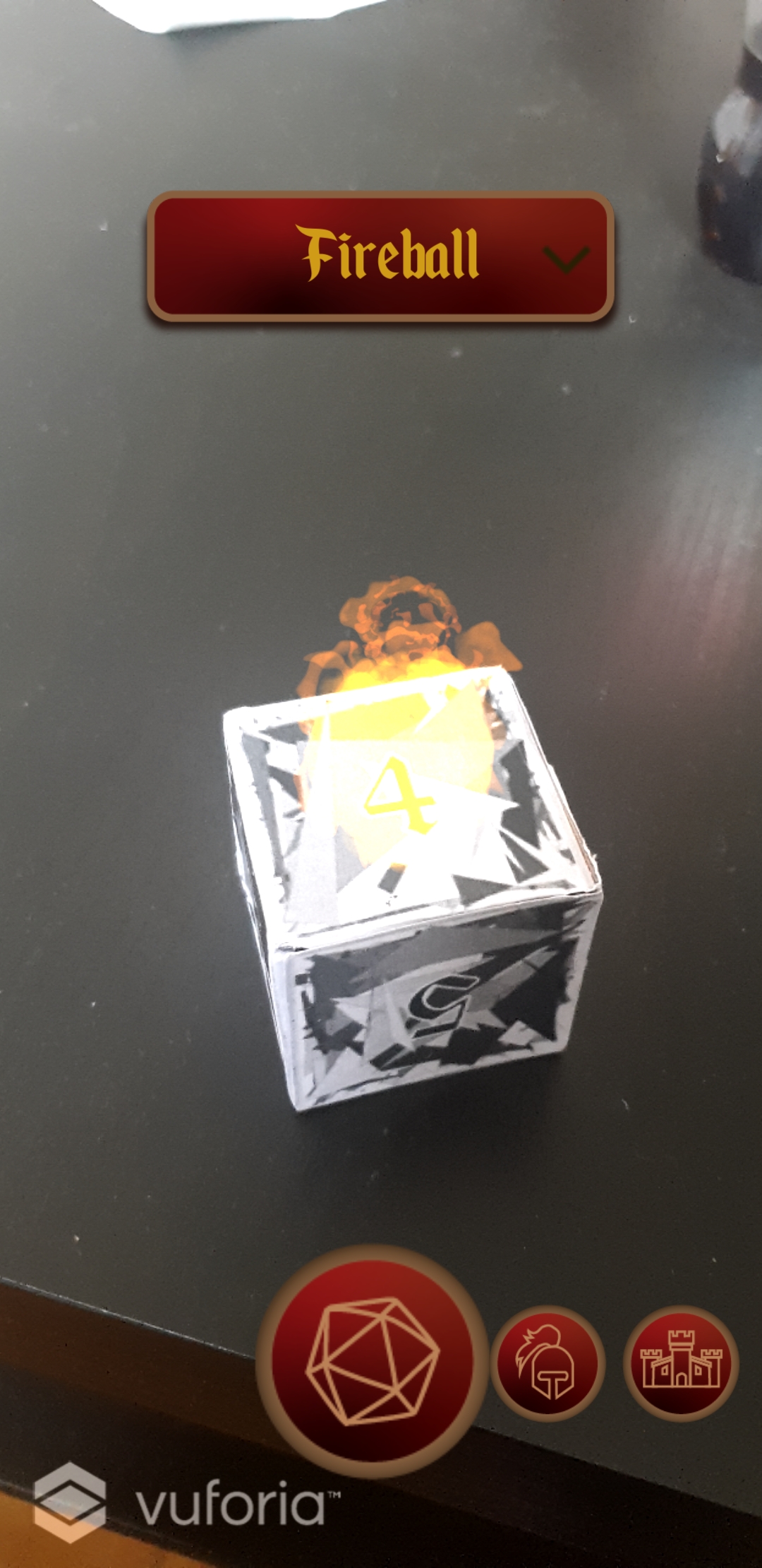 Photograph of dice with 3d model of fire projected to the top of it. UI shows enlarged centre circle button with a dice icon, and two smaller circle buttons with icons of armor and a castle